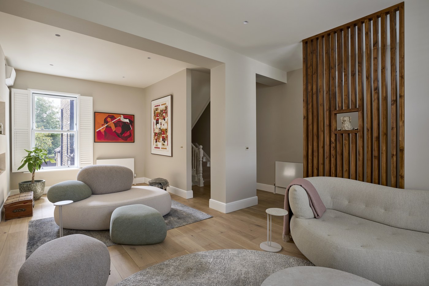 Open-plan living space at Achilles Road looking back to the staircase, with a timber slatted screen