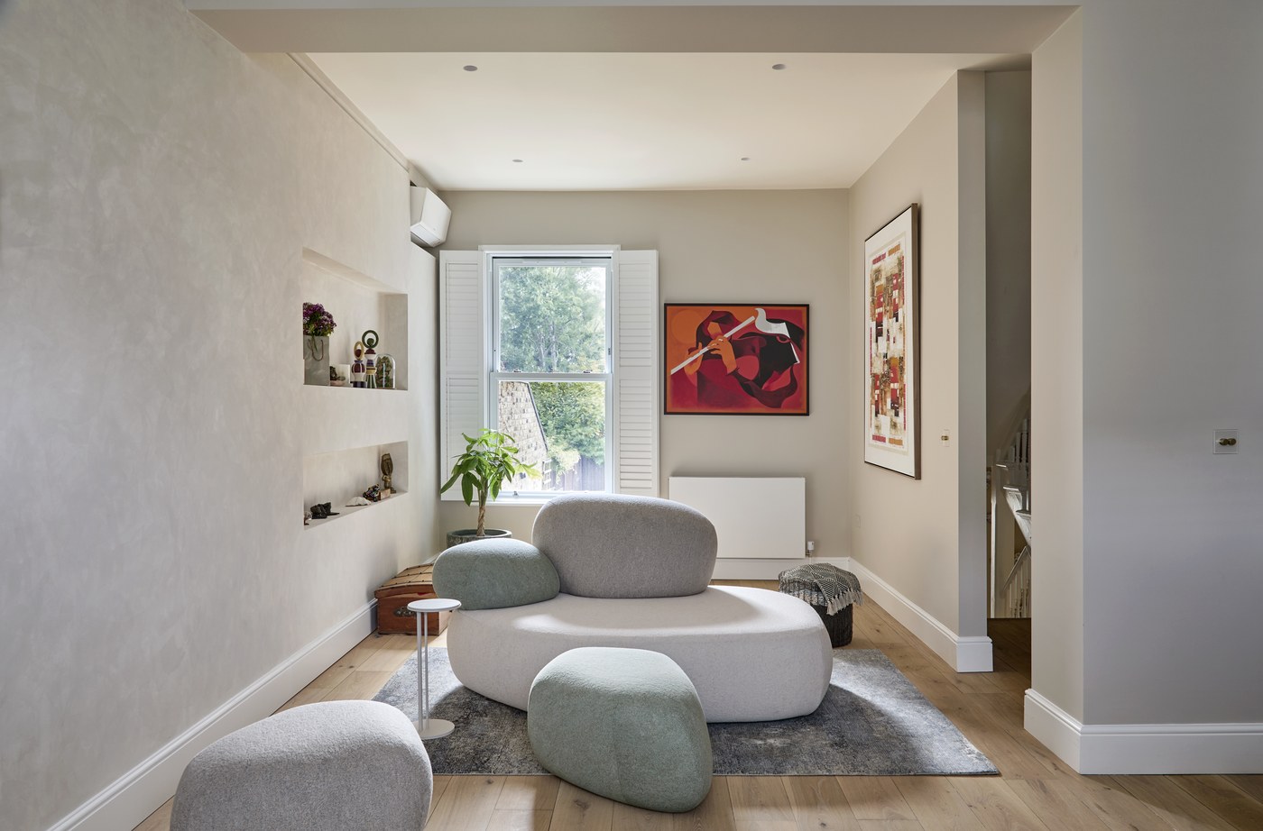 Refurbished reception room at Achilles Road with recessed shelving and curved seating