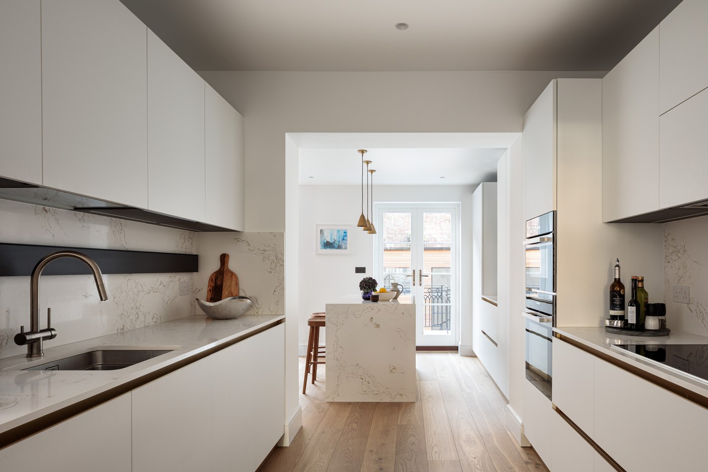 Bespoke kitchen at Brompton Square running the length of the plan, with stone worktops and integrated appliances
