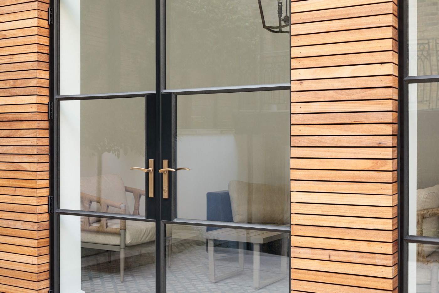 Detail of the steel door ironmongery against horizontal timber cladding at Brompton Square