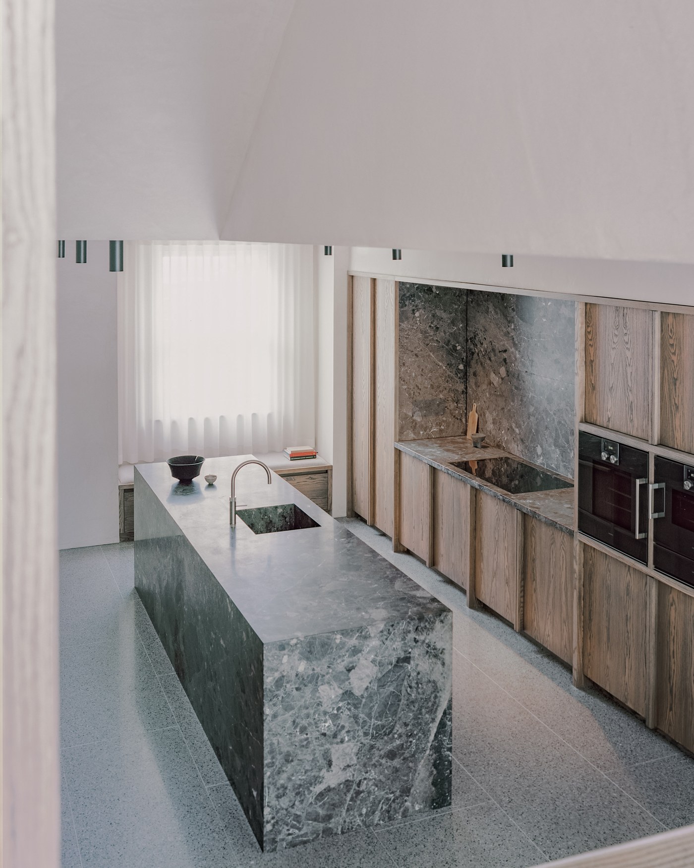 Caithness Road W14 — kitchen with a solid stone island, stone splashback and full-height bespoke ash joinery