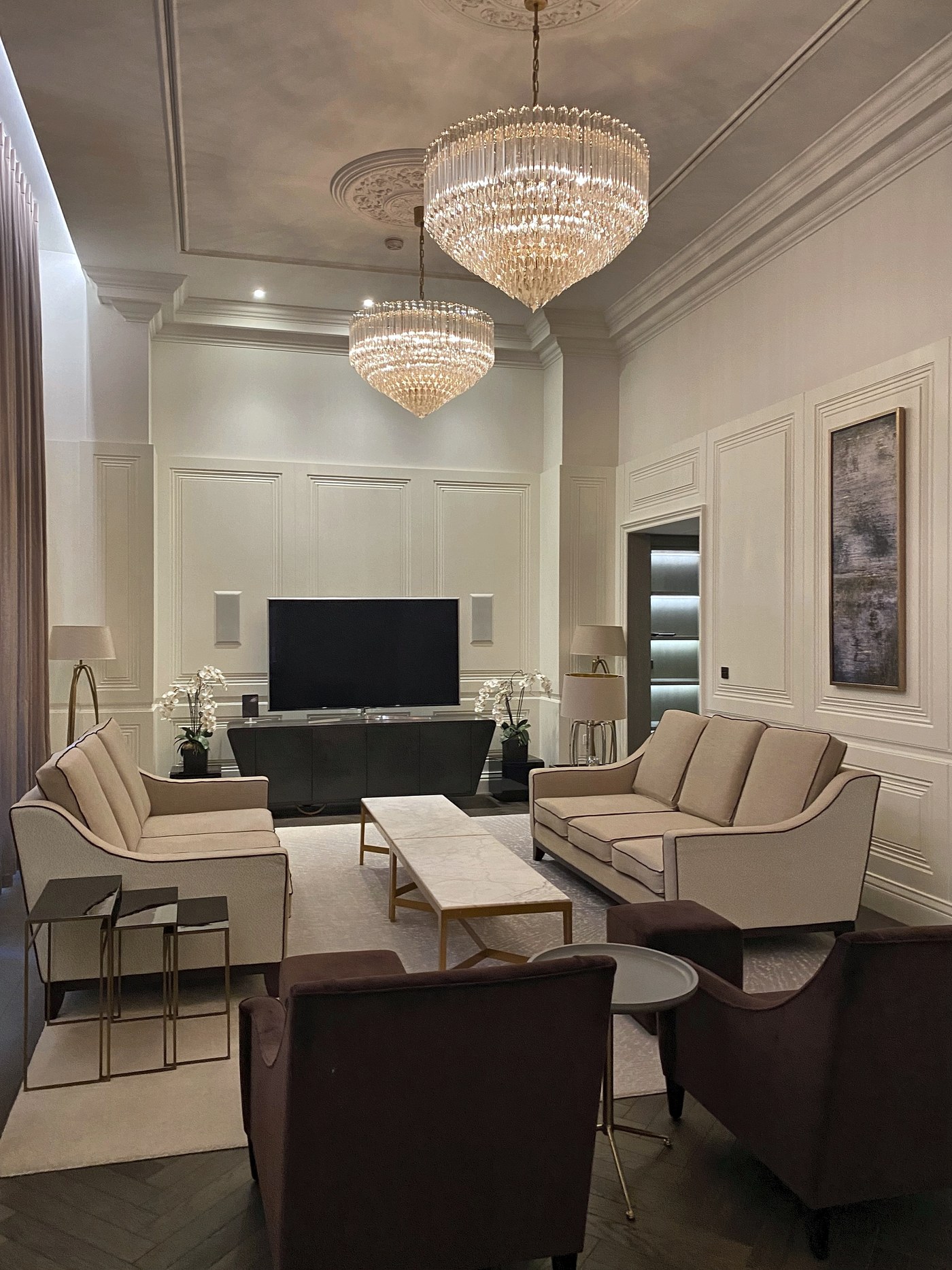 Drawing room at Connaught Place with full-height painted panelling, cornice and a chandelier