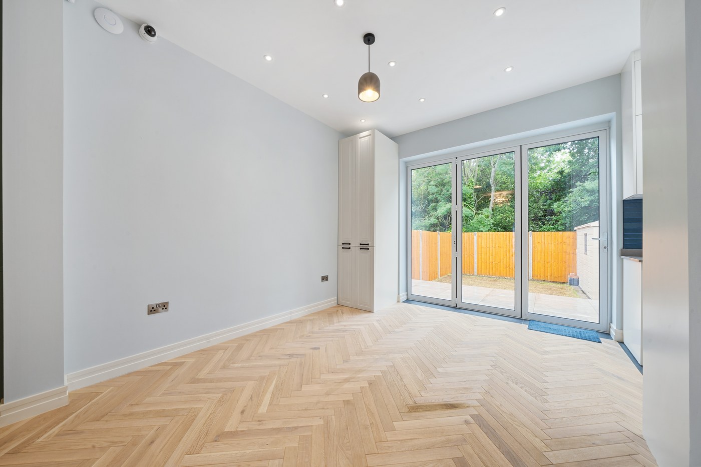 Living room at Millway with new herringbone flooring and doors to the garden