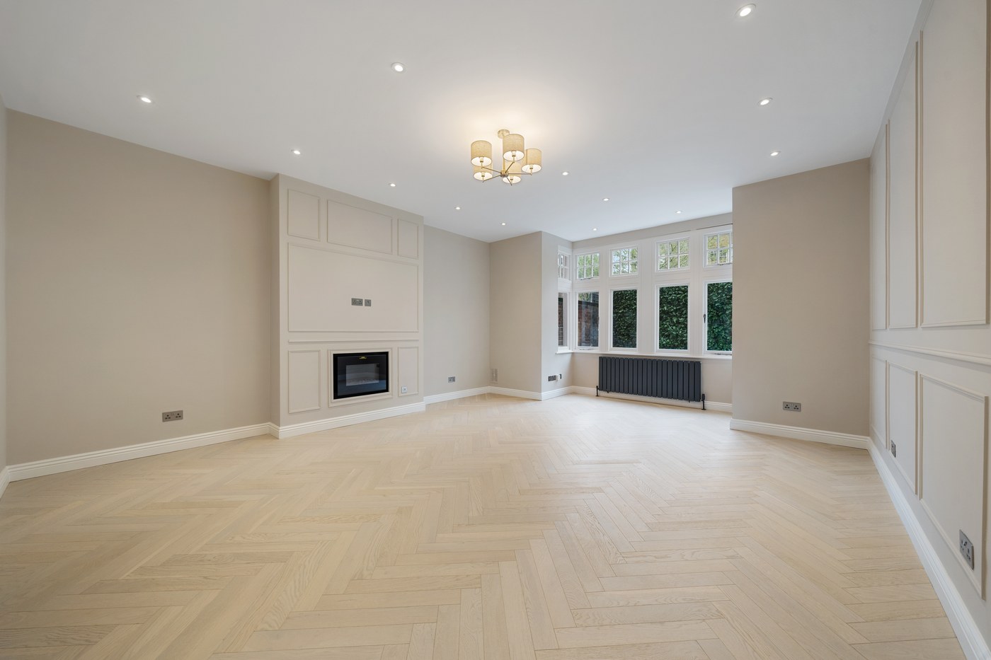 Panelled reception room at St John's Wood Road with a chimneypiece and herringbone flooring